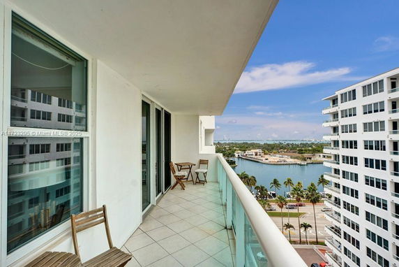 Balcony view with nearby buildings and water in the background.