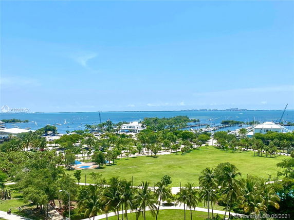 Panoramic view of a coastal area with greenery and water in the background.