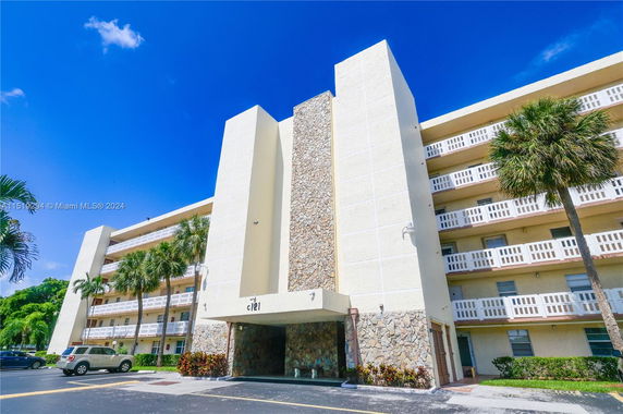 Front view of a multi-story building with a unique stone facade and multiple balconies.