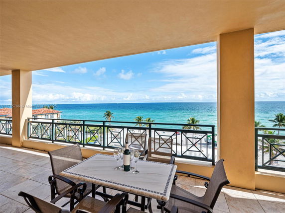 Wide angle view of the beach and ocean from a balcony.