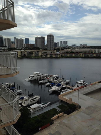 View from a building overlooking a marina and city skyline in the distance.