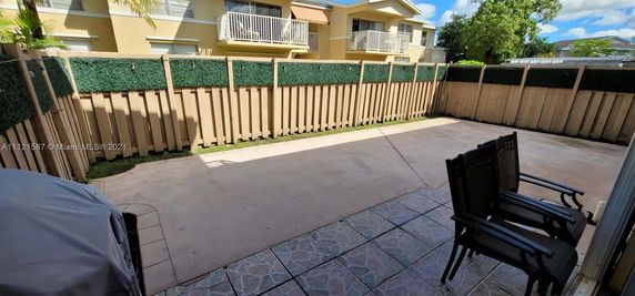 Outdoor fenced area with view of a residential building with balconies.