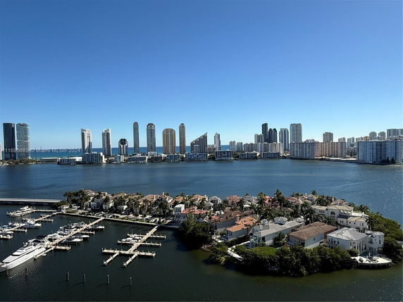 Panoramic view of waterfront residential area with high-rise buildings in the distance.