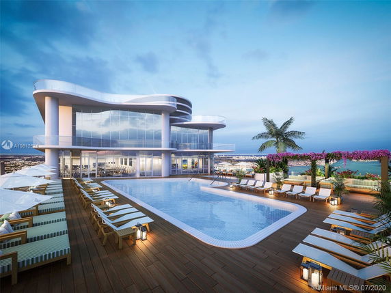 Modern rooftop with a large pool, sun loungers, and a sleek building with extensive glass windows.