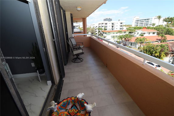 View from a balcony overlooking nearby residential buildings and trees.