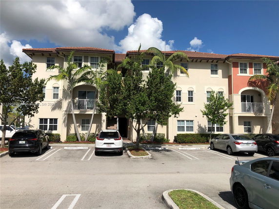 Front view of a three-story residential building with balconies.