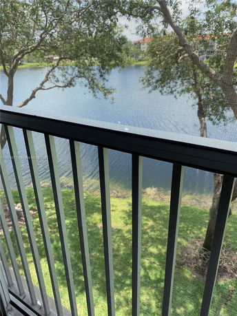 View from a screened balcony overlooking a body of water with trees.