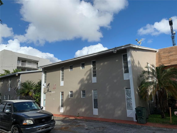 Front view of a two-story building with multiple windows and satellite dishes.
