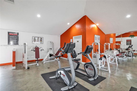 Indoor gym area with exercise equipment and mirrored walls.