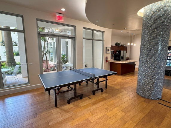 Indoor area with a table tennis setup and seating area.