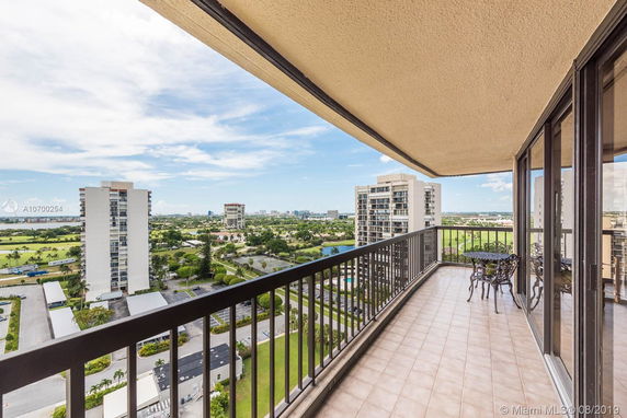 View from a balcony overlooking a cityscape with high-rise buildings.