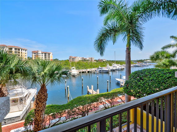 View of a marina with boats and surrounding condominiums.