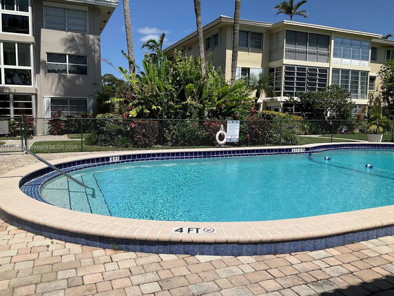 Outdoor swimming pool in front of a residential building.