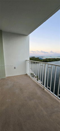 View from a balcony overlooking water and distant greenery.