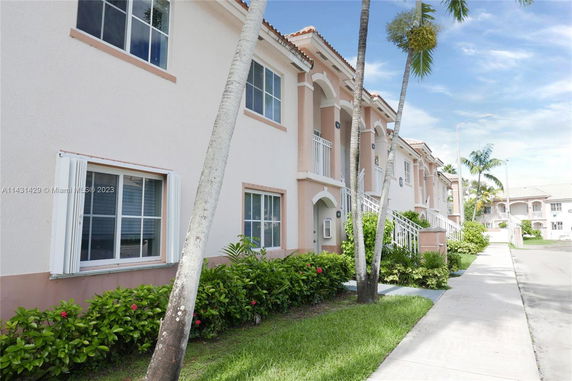 Front view of a two-story residential building with multiple units and balconies.