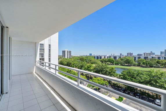 Balcony view overlooking a cityscape and green areas with a river.