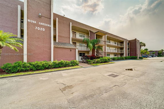 Front view of a multi-story apartment building with balconies.