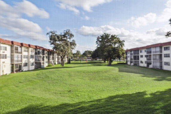 View of a grassy area with surrounding multi-story buildings.