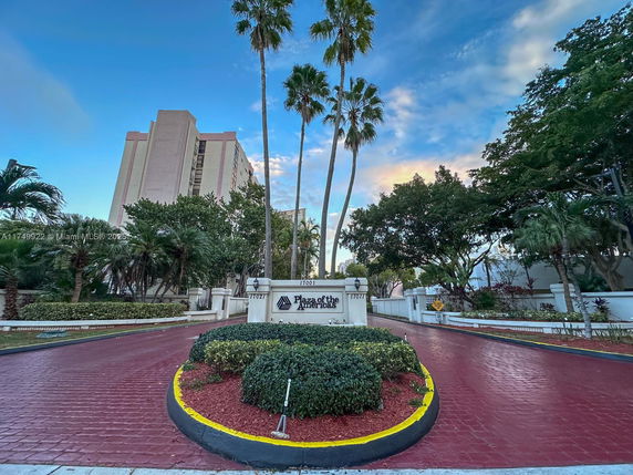 Front view of a multi-story residential building with a landscaped entrance.