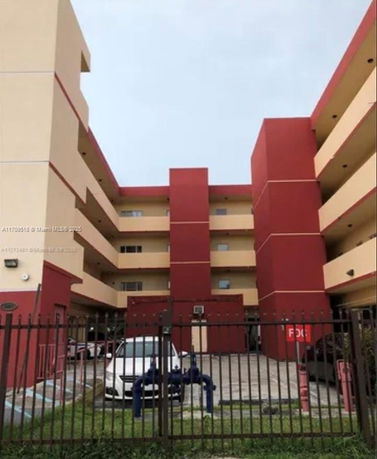 Front view of a multi-story building with a red and beige facade.