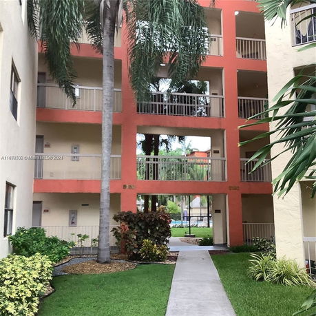 Exterior view of a multi-story apartment building with a central walkway.