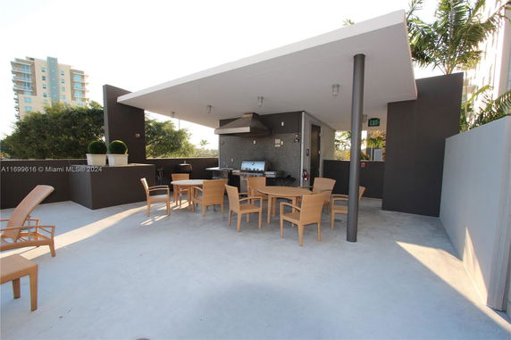 Rooftop area with tables, chairs, and a barbecue setup.