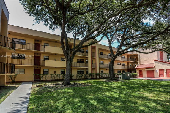 Front view of a three-story apartment building with balconies.