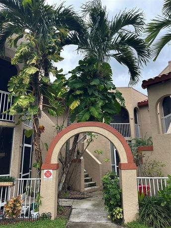 Front view of a multi-story residential building with an archway entrance.