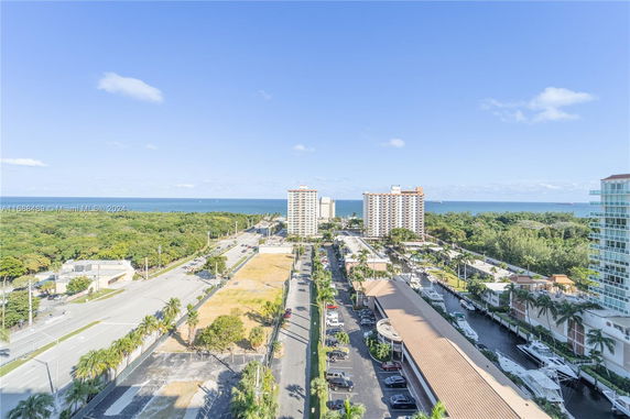 Wide-angle view of a coastal urban area with buildings and a distant sea.