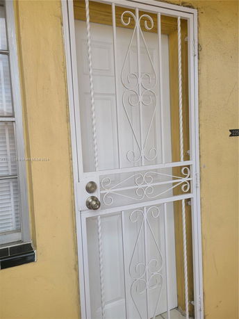 Close-up view of a front door with decorative white security bars.