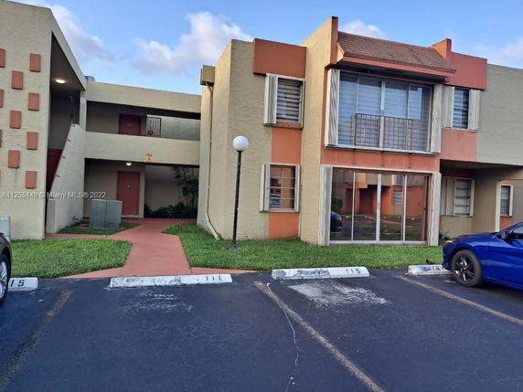 Front view of a two-story residential building with parking area.