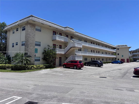 Front view of a multi-story residential building with exterior staircases and multiple balconies.