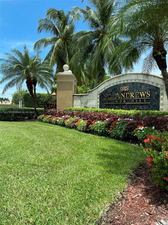 Entrance sign for St. Andrews at Nob Hill Condominiums surrounded by palm trees and landscaping.