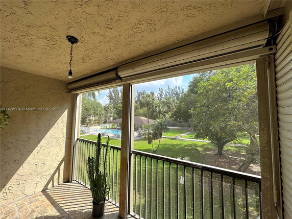 Elevated view of surrounding greenery and swimming pool from a balcony.