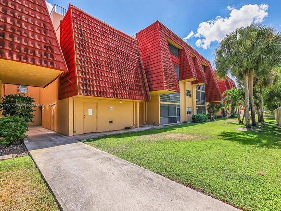 Front view of a building with distinctive red sloped roof design.
