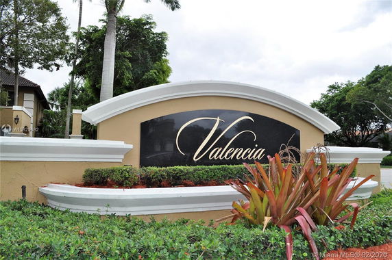 Front view of an entrance sign for Valencia community with landscaping.