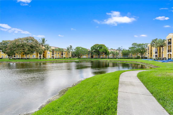 View of yellow multi-story apartment buildings next to a lake.
