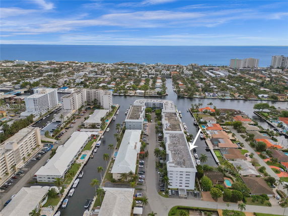 Aerial view of a coastal cityscape with multiple residential buildings and waterways.