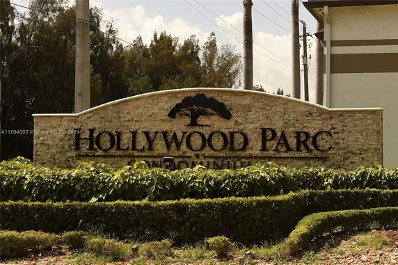 Signage for Hollywood Parc condominium with greenery around.