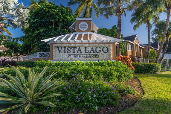 Front view of a residential complex with a sign reading 'Vista Lago at the Hammocks'.