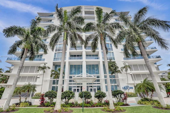 Front view of a multi-story modern building with large windows and balconies.