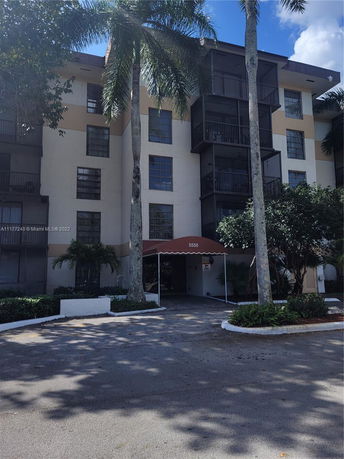 Front view of a multi-story residential building with a covered entrance.