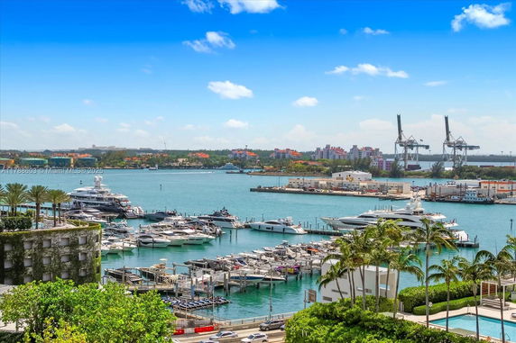 Panoramic view of a marina with several yachts and boats docked at the waterfront.