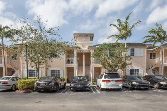 Front view of a two-story residential building with balconies and staircases.
