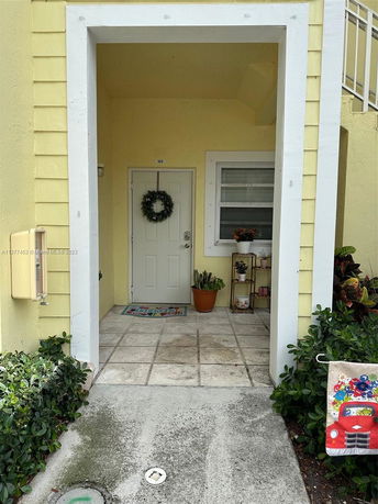 Front entrance of a house with a doorway and window, decorated with a wreath.