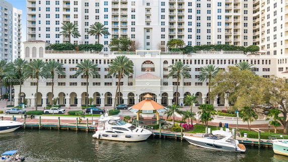 Front view of a multi-story building with balconies and palm trees.