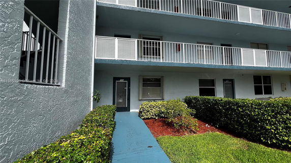 Front view of a multi-story building with balconies and entrance walkway