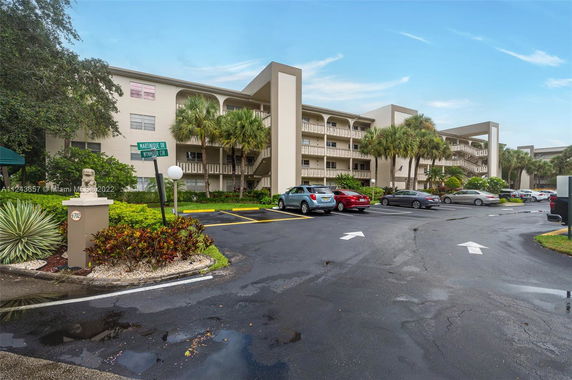 Parking area in front of a multi-story residential building.
