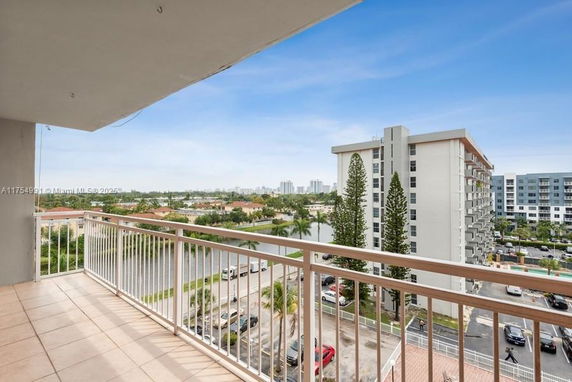 View from a balcony overlooking a residential area with multi-story buildings.