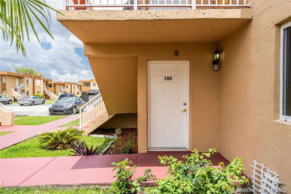 Front view of a multi-unit apartment entrance with door number 102.